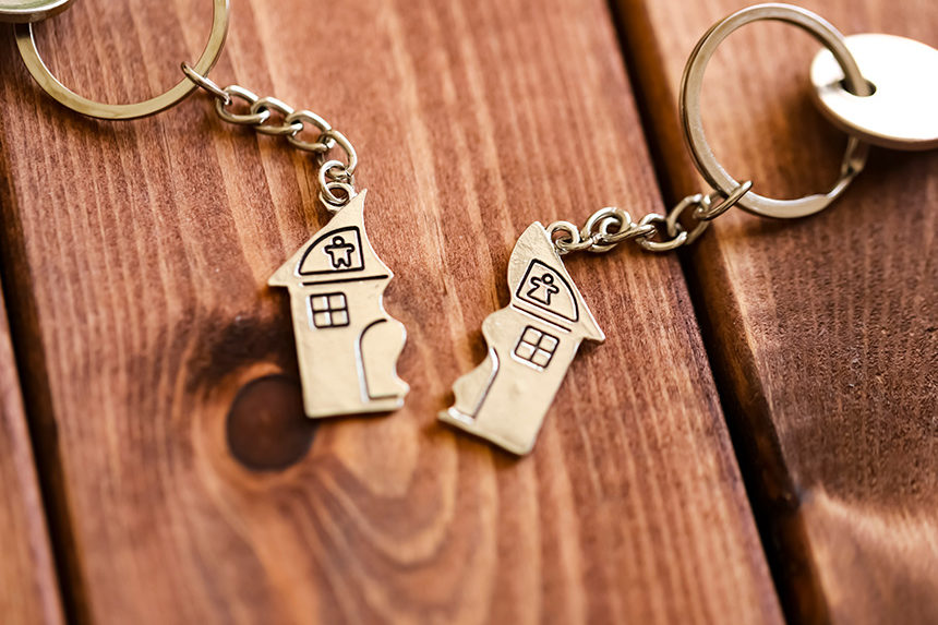 A pair of keychain decorations, each representing one half of a house. Symbolizes a broken home following a divorce or a romantic breakup.
