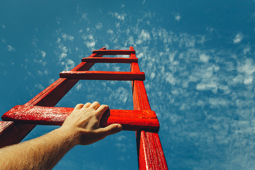 A photo showing a man's point-of-view as he climbs a wooden ladder towards the sky.