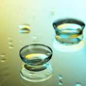 A pair of soft contact lenses on a wet surface