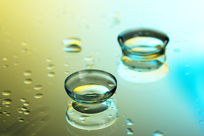 A pair of soft contact lenses on a wet surface