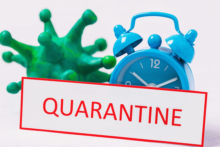 A giant green germ sits next to an alarm clock and a sign that reads "Quarantine"