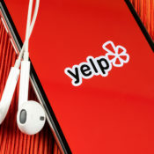 A smartphone with the Yelp app displayed on its screen