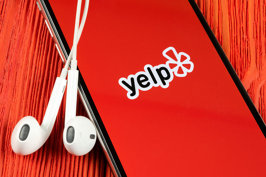 A smartphone with the Yelp app displayed on its screen