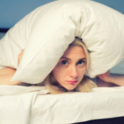 Woman hiding underneath a pillow