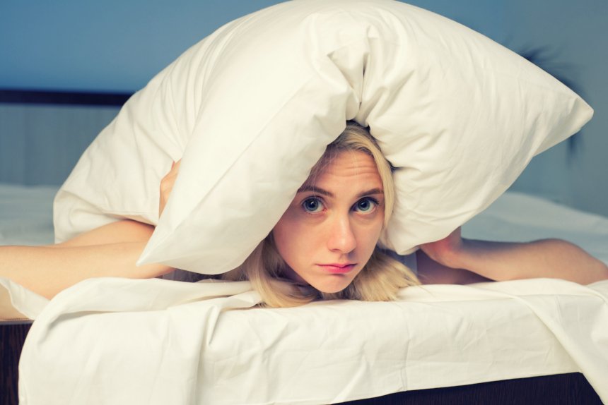 Woman hiding underneath a pillow