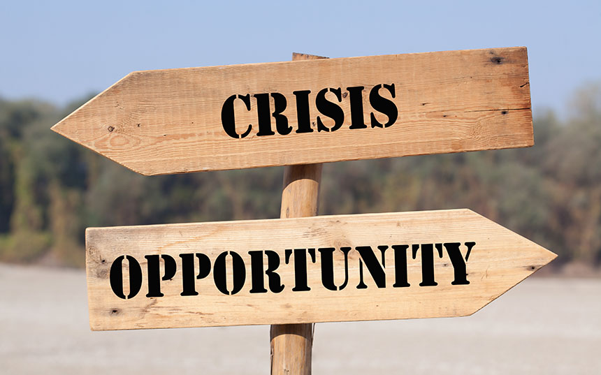 A crossroads sign with the words "crisis" and "opporunity"