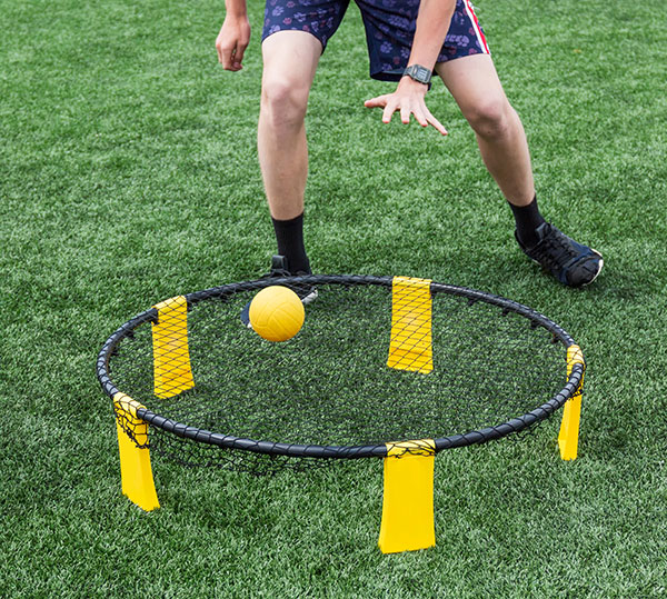 A kid playing Spikeball