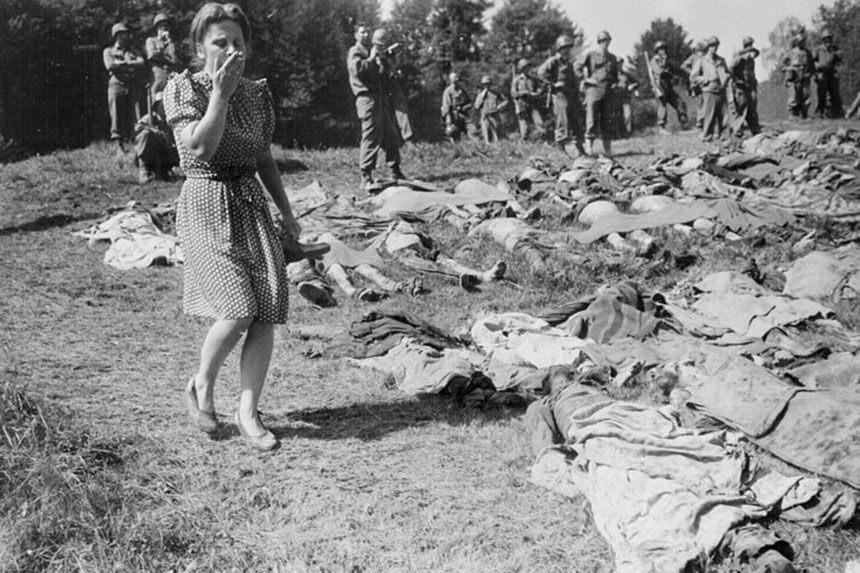 A German woman recoils in horror as she is forced to walk and examine bodies of slaves found in a Nazi concentration camp