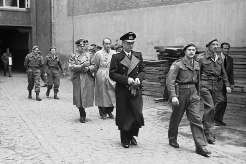 Nazi commanders Karl Donitz, Albert Speer, and Alfred Jodi are led away by British military officers