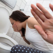Woman about to vomit into a toilet