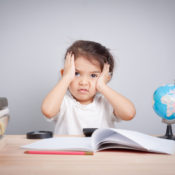 Young girl holding her head with an bemused look on her face