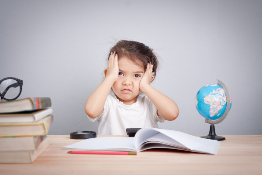 Young girl holding her head with an bemused look on her face