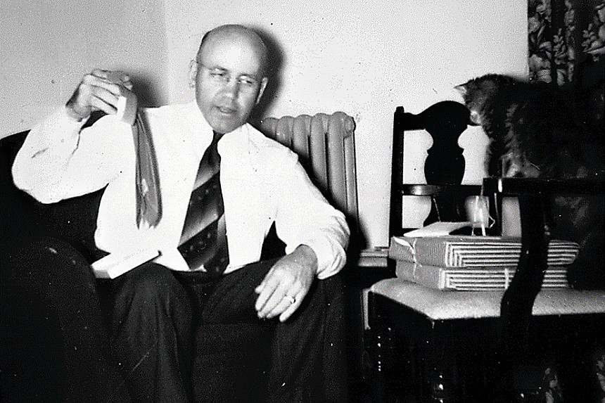 Val Lauder's dad holding a tie in front of a cat.