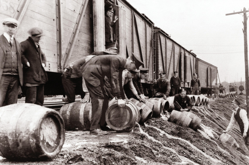 Prohibition agents break open barrels of illegal alcohol