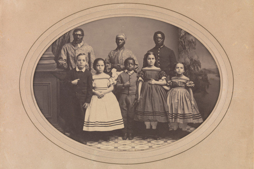 A 19th century photography of black servants and the white children in their charge.