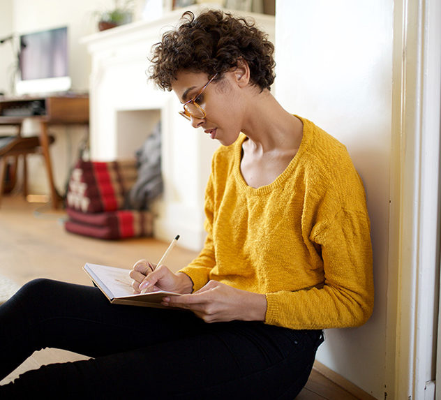 Young woman writing into her notebook.