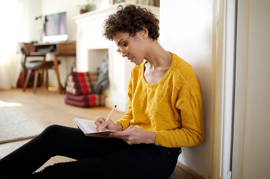 Young woman writing into her notebook.