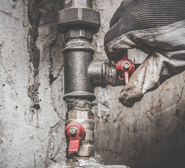 Plumber tightening a valve on a pipe