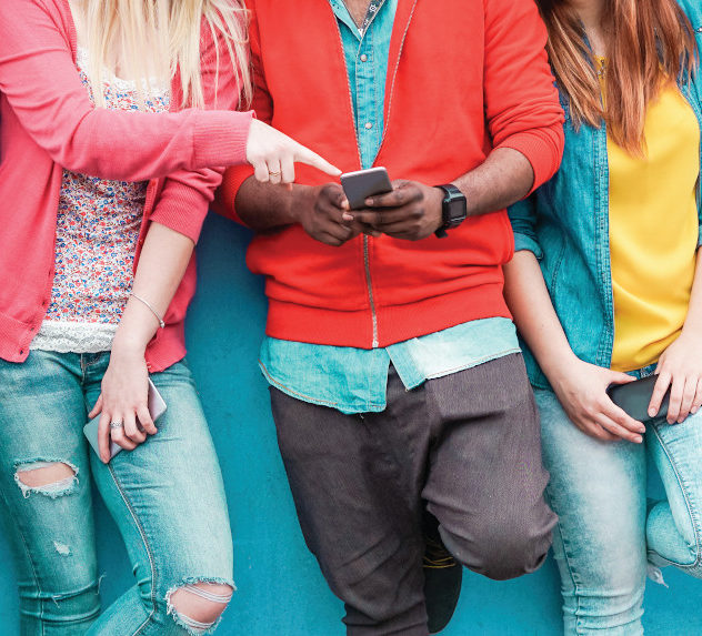 A group of millennials looking at a mobile phone.