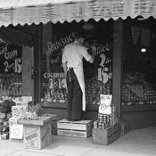 Grocer and Minneapolis putting up marketing signs outside of his store.