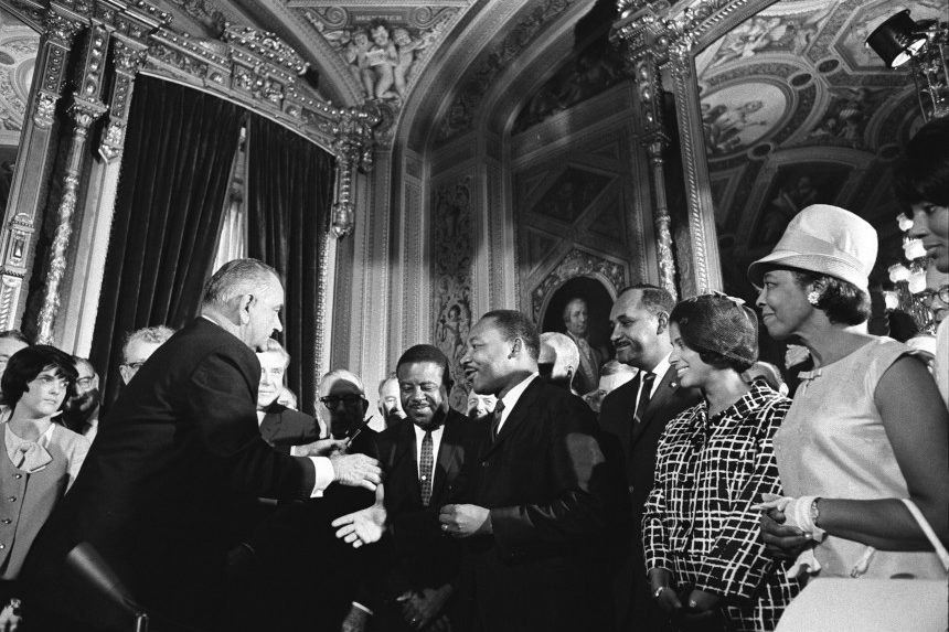 President Lyndon Bird Johnson handing the pen he used to sign the 1964 Voting Rights Act to Martin Luther King, Jr.