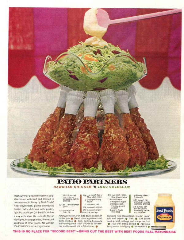 Mayo being placed on a salad that sits atop a tower of chicken legs