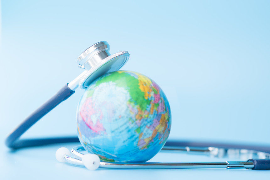 A stethoscope rests on a miniature globe