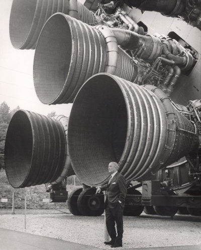 Scientist Wernher von Braun in front of a rocket booster