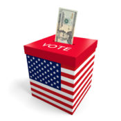 An American dollar being pushed into a voting box