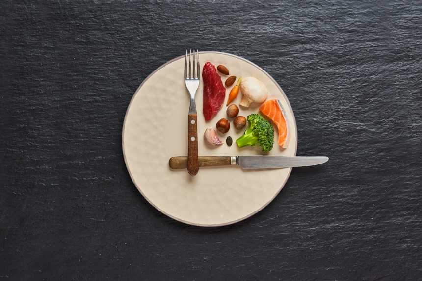 A plate of food and silverware arranged to look like a clock face and hands