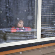 Kid looking outside during a snow storm