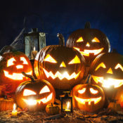 Lit Jack-O'-Lanterns grinning in the dark