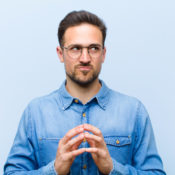 Man tapping his fingers together in a scheming manner.