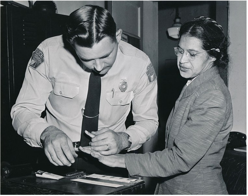 Rosa Parks being fingerprinted in a police station.