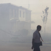 Worker walks past a smog covered row of buildings near the North Birmingham Pipe Plant
