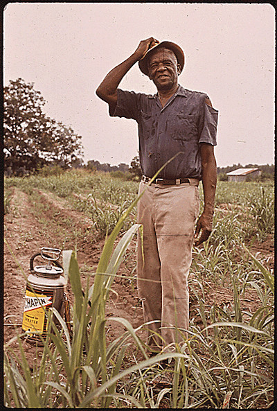 Farmer with a large can of pesticide