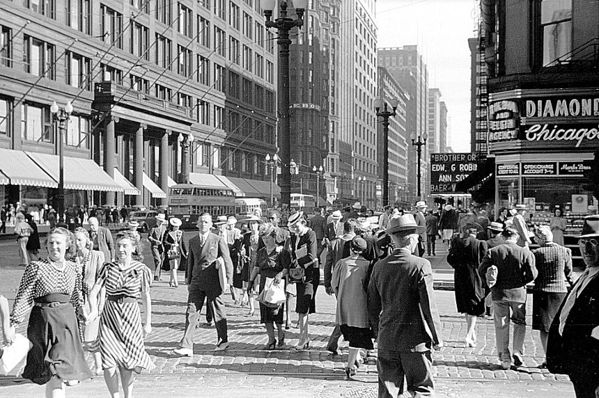 People moving about on a busy street in 1940s Chicago