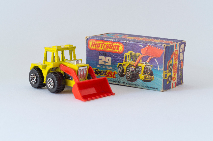 A Matchbox bulldozer toy next to its box.