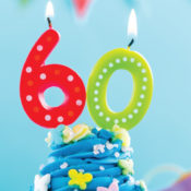 Numerical candles that form "60" atop a cupcake