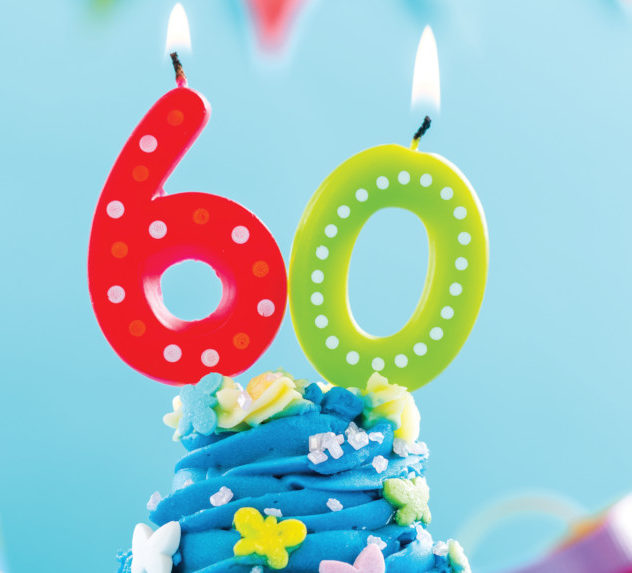 Numerical candles that form "60" atop a cupcake