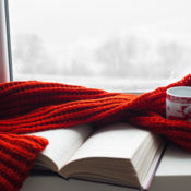 Books, coffee and a scarf on a window sill during a cold winter morning