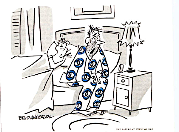 Man with eyeball-pattern pajamas sits up in bed.