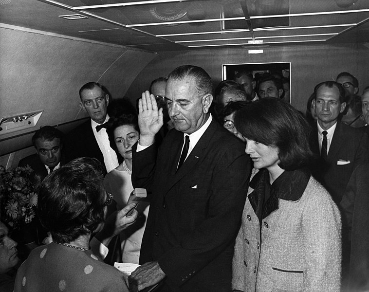 Photo of Lyndon B. Johnson taking the oath of office aboard Air Force One.