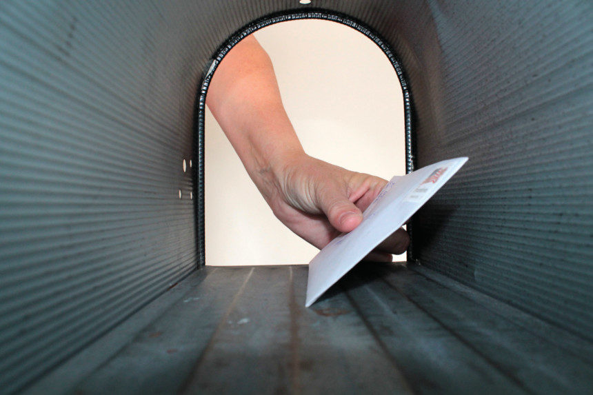 Man putting letter into mailbox