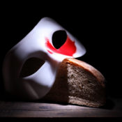 A mask rests on a loaf of bread.