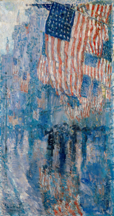 American flags and a crowd of people on a city street during a rain storm.