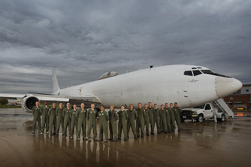 The crew for the E-6B Mercury aircraft pose with the plane at Minot Air Force Base