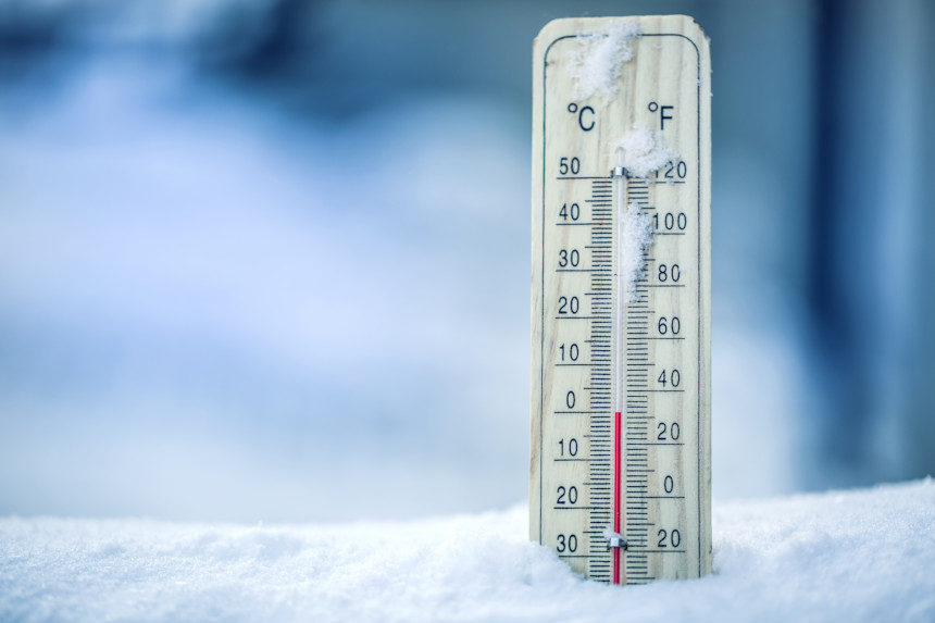 A frozen thermometer in the snow.