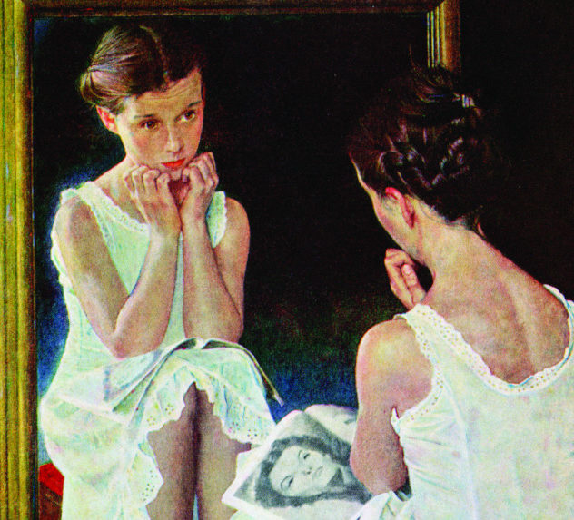 A young girl looks at herself in the mirror, comparing her looks to the Hollywood actress in her magazine.