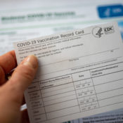 Woman holding her COVID-19 vaccination card.